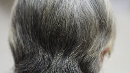 Asian woman with white skin, gray hair, sitting with her back, Photo of the back.